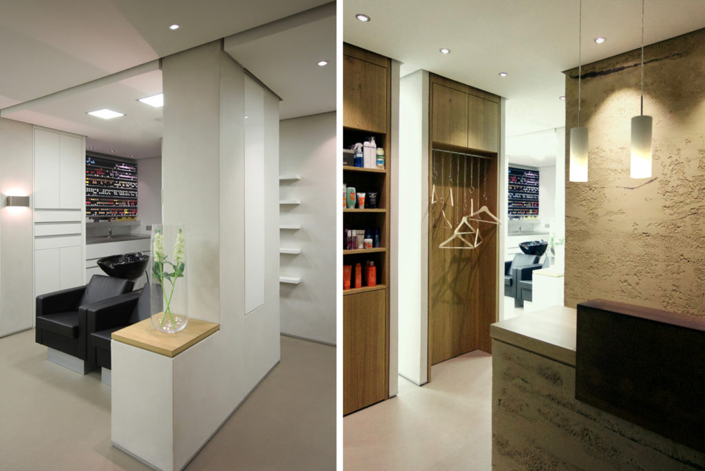 Ein modernes Interieur mit einem Salon mit eleganten Designelementen. Links sind schwarze Salonstühle und Regale mit Produkten zu sehen. Rechts verleiht ein Empfangsbereich mit Holzakzenten und Hängelampen dem minimalistischen Raum Wärme.