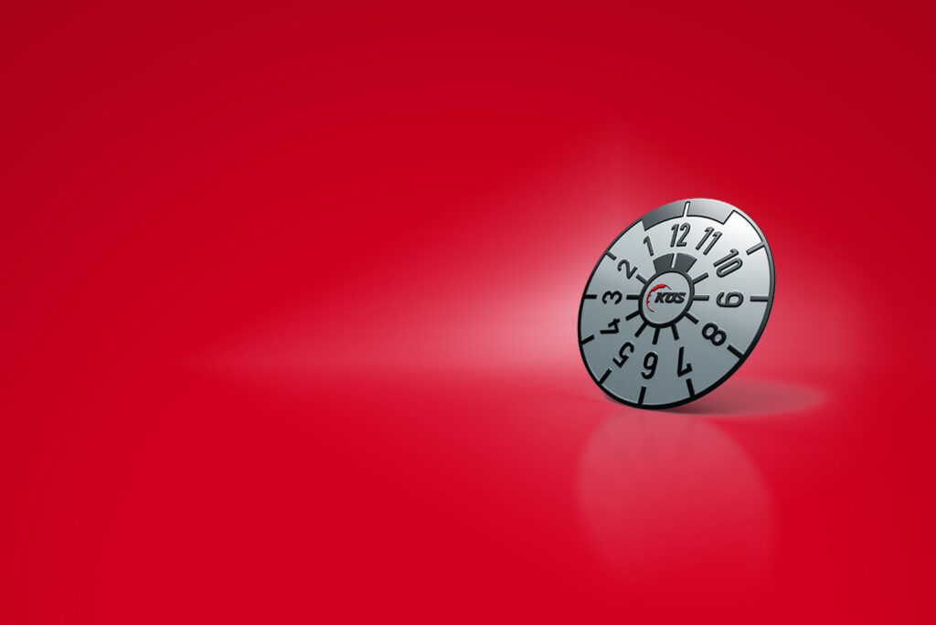 Ein rundes Zifferblatt mit den Zahlen 1 bis 12 und dem Wort „POGS“ in der Mitte, vor einem leuchtend roten Hintergrund. Das Zifferblatt wirft einen leichten Schatten und vermittelt so ein Gefühl von Tiefe und Dimension.