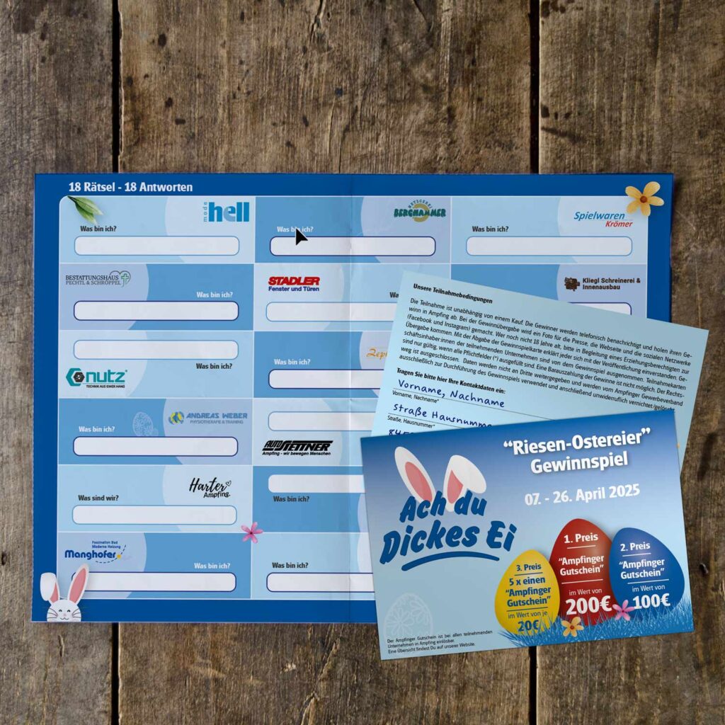 Auf einer Holzfläche liegen ein Spielbogen und ein Werbeflyer mit dem Titel „Ach du dickes Ei“. Der Bogen enthält Antwortfelder mit Logos, der Flyer wirbt für ein Oster-Gewinnspiel vom 2. bis 26. April 2025, bei dem unter anderem ein Ampfinger-Gutschein als Preis lockt.