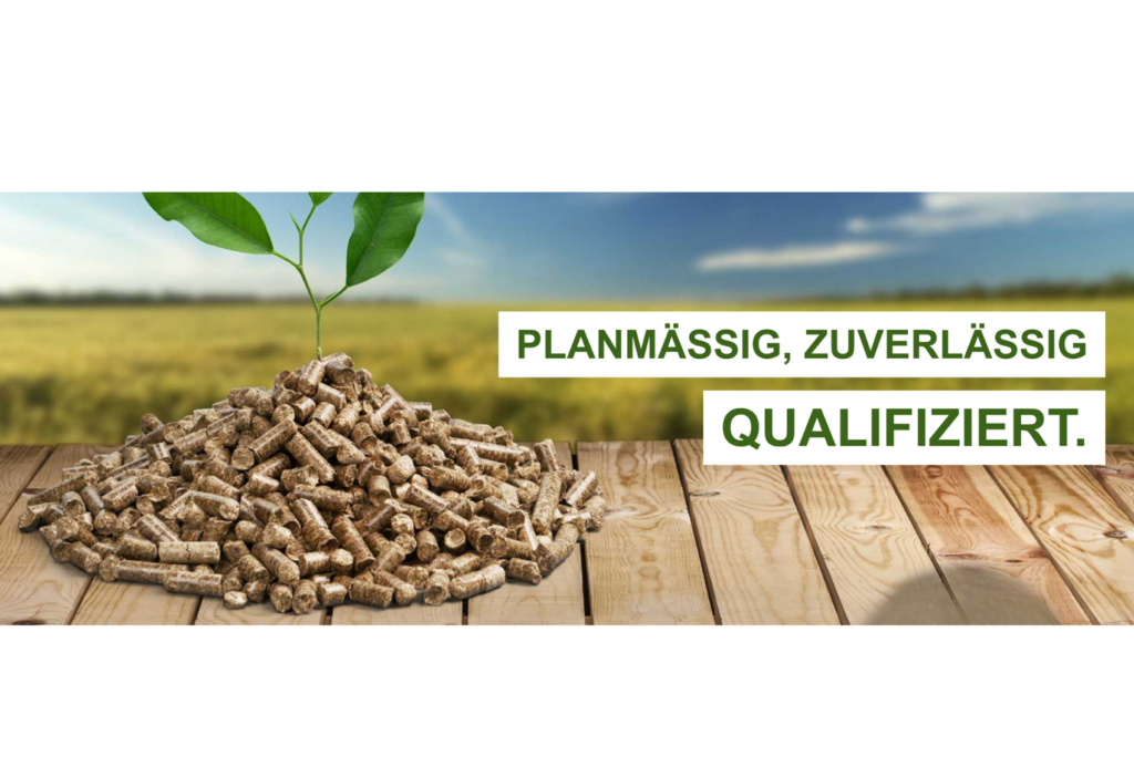 Ein Haufen Holzpellets mit einer kleinen grünen Pflanze, die auf einer hölzernen Fläche wächst, mit einem Feld und blauem Himmel im Hintergrund. Der Text lautet: "PLANMÄSSIG, ZUVERLÄSSIG, QUALIFIZIERT.