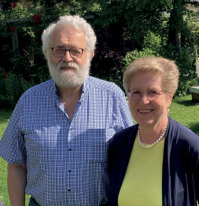 Ein älteres Ehepaar, das gemeinsam draußen in einem Garten steht.